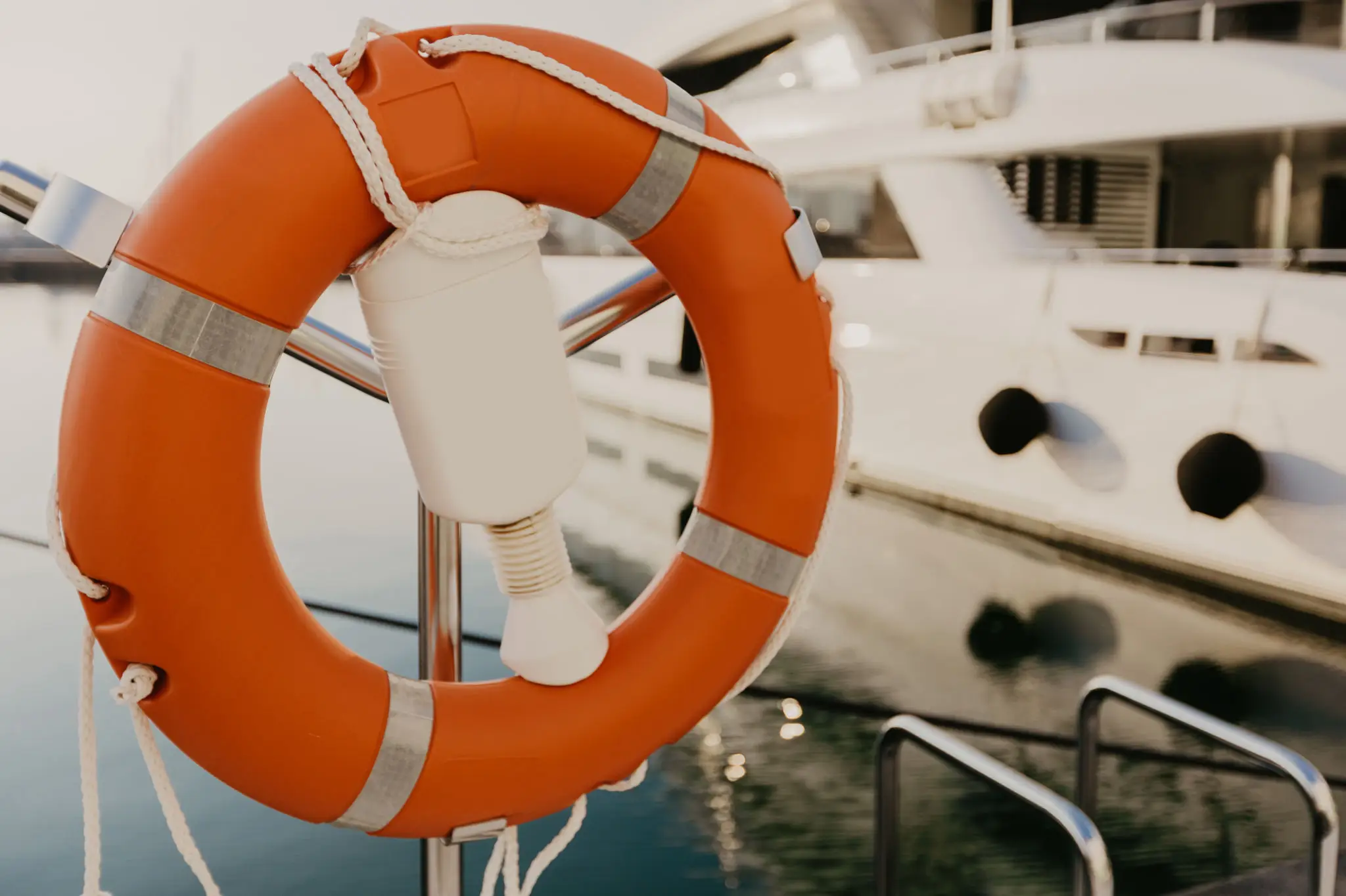 Orange lifebuoy on yacht near water.