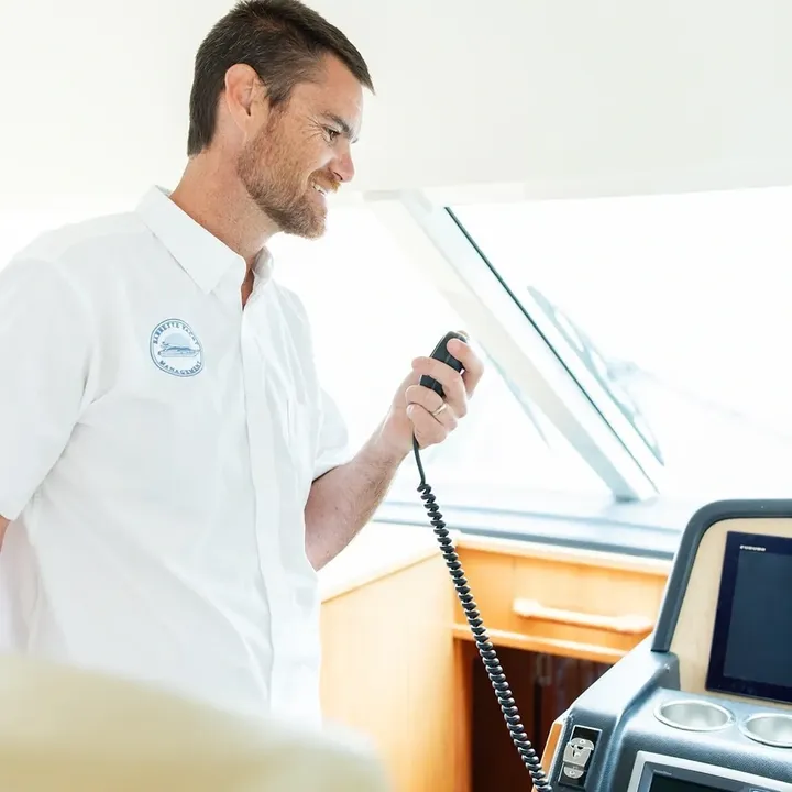 Man speaking into a radio on boat.