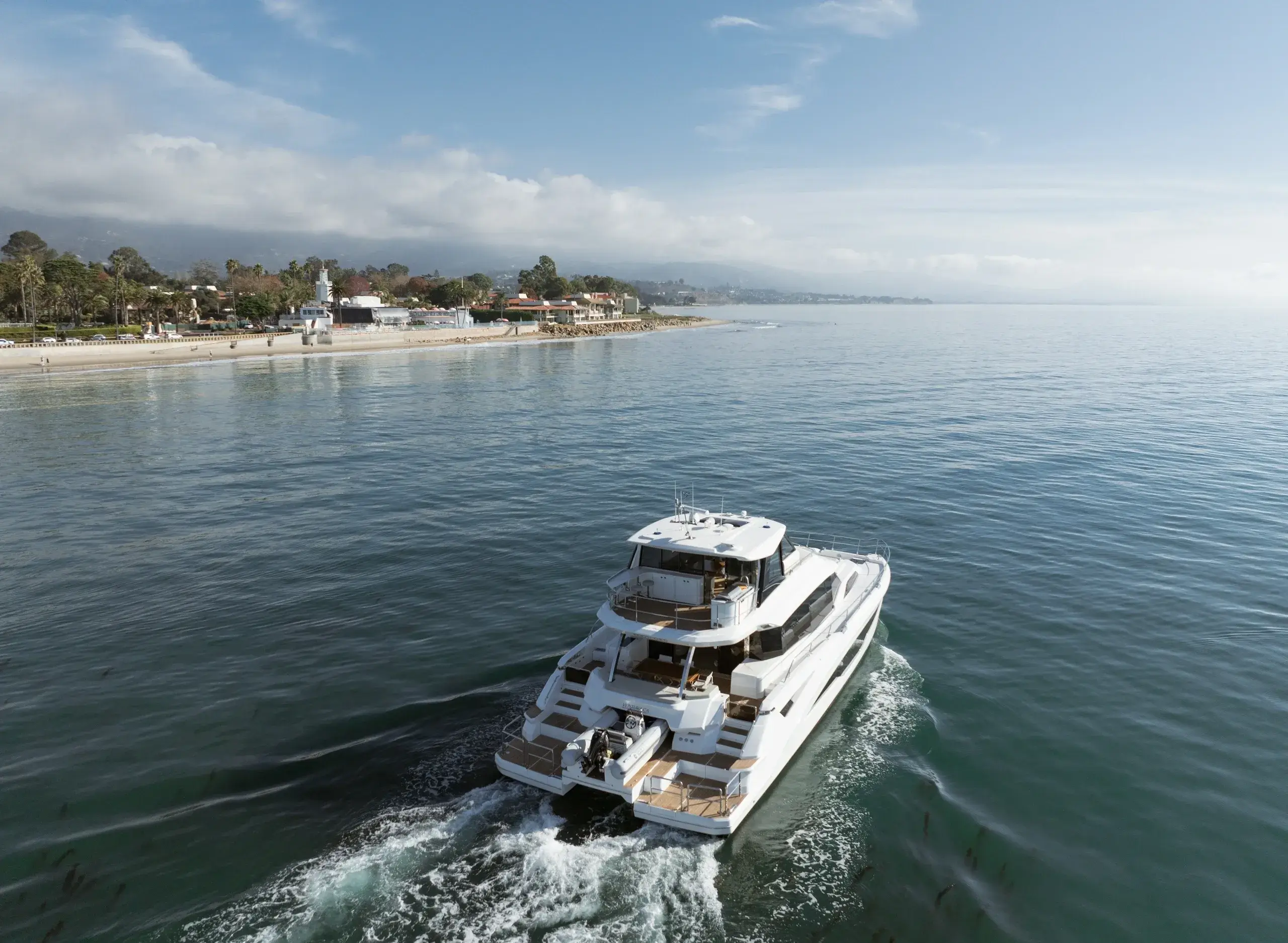 Luxury yacht cruising near a scenic coastline.