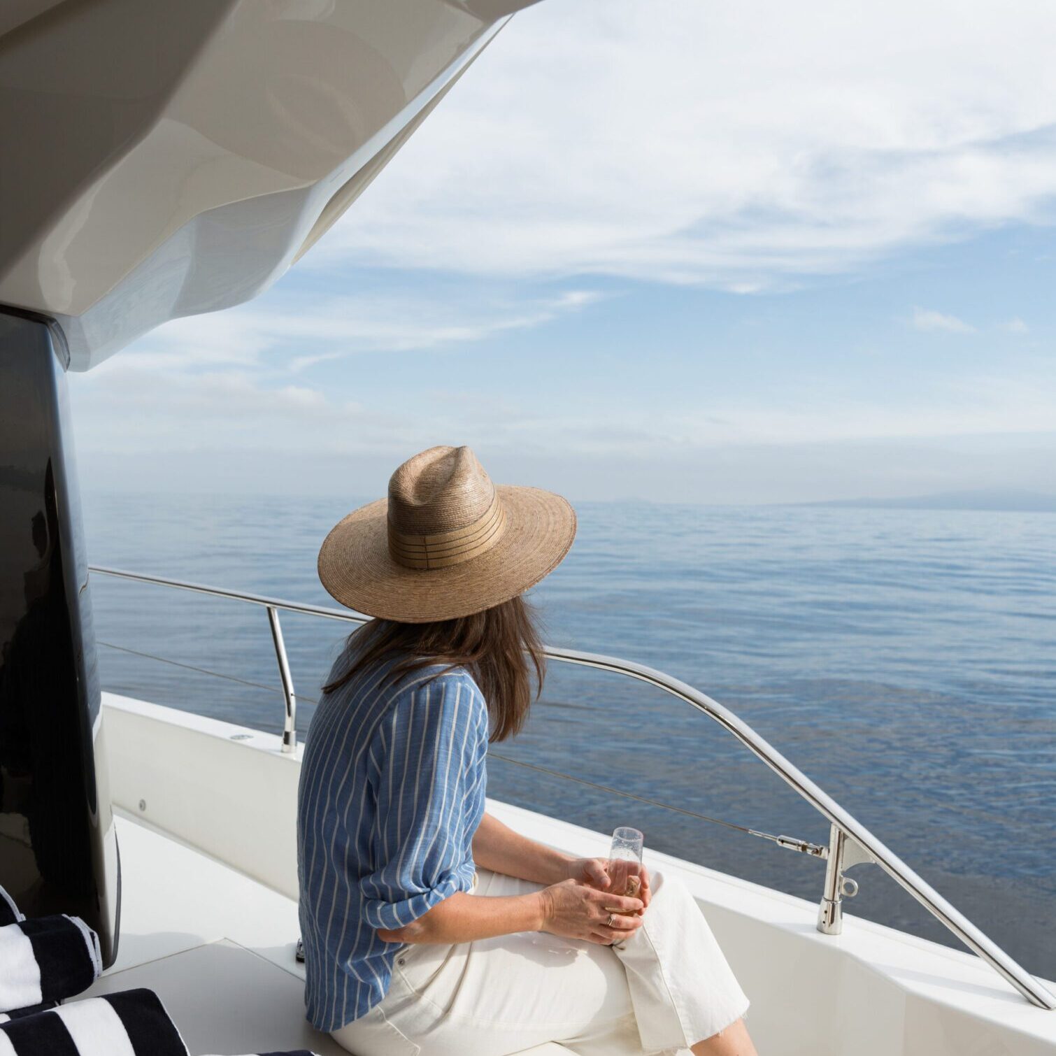 Woman relaxing on yacht, looking at sea.