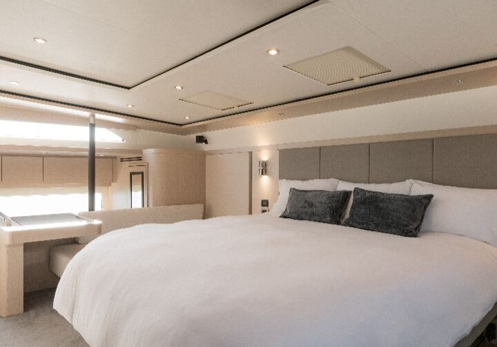 Modern bedroom with a large bed and soft lighting.