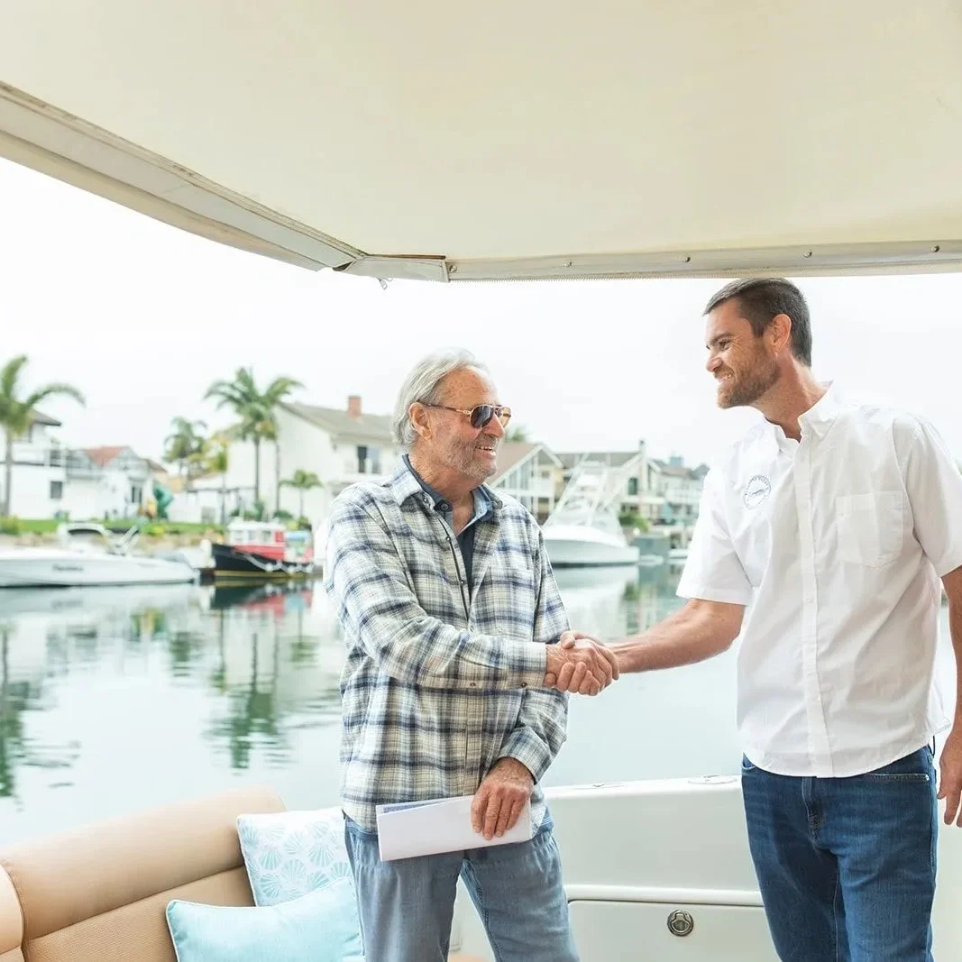 Two men shaking hands on a boat.