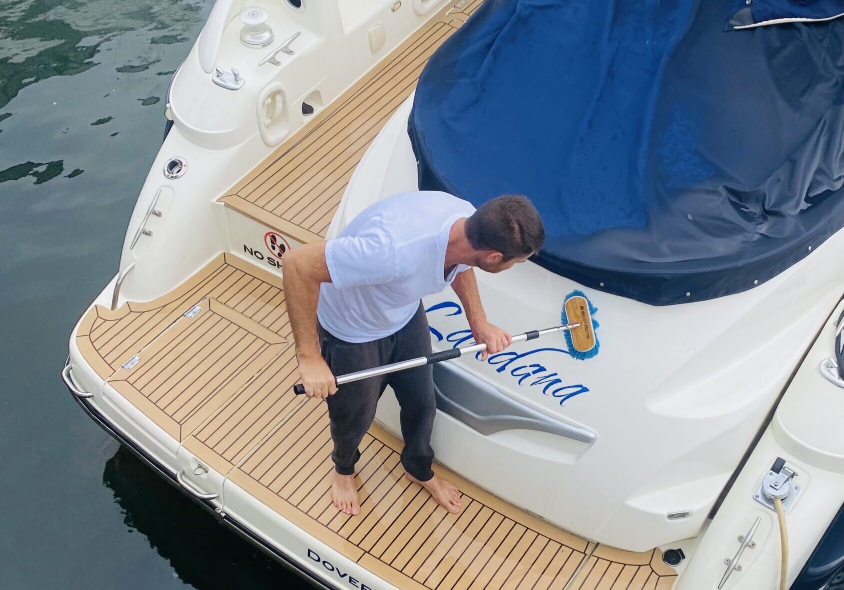 Man cleaning the deck of a yacht.